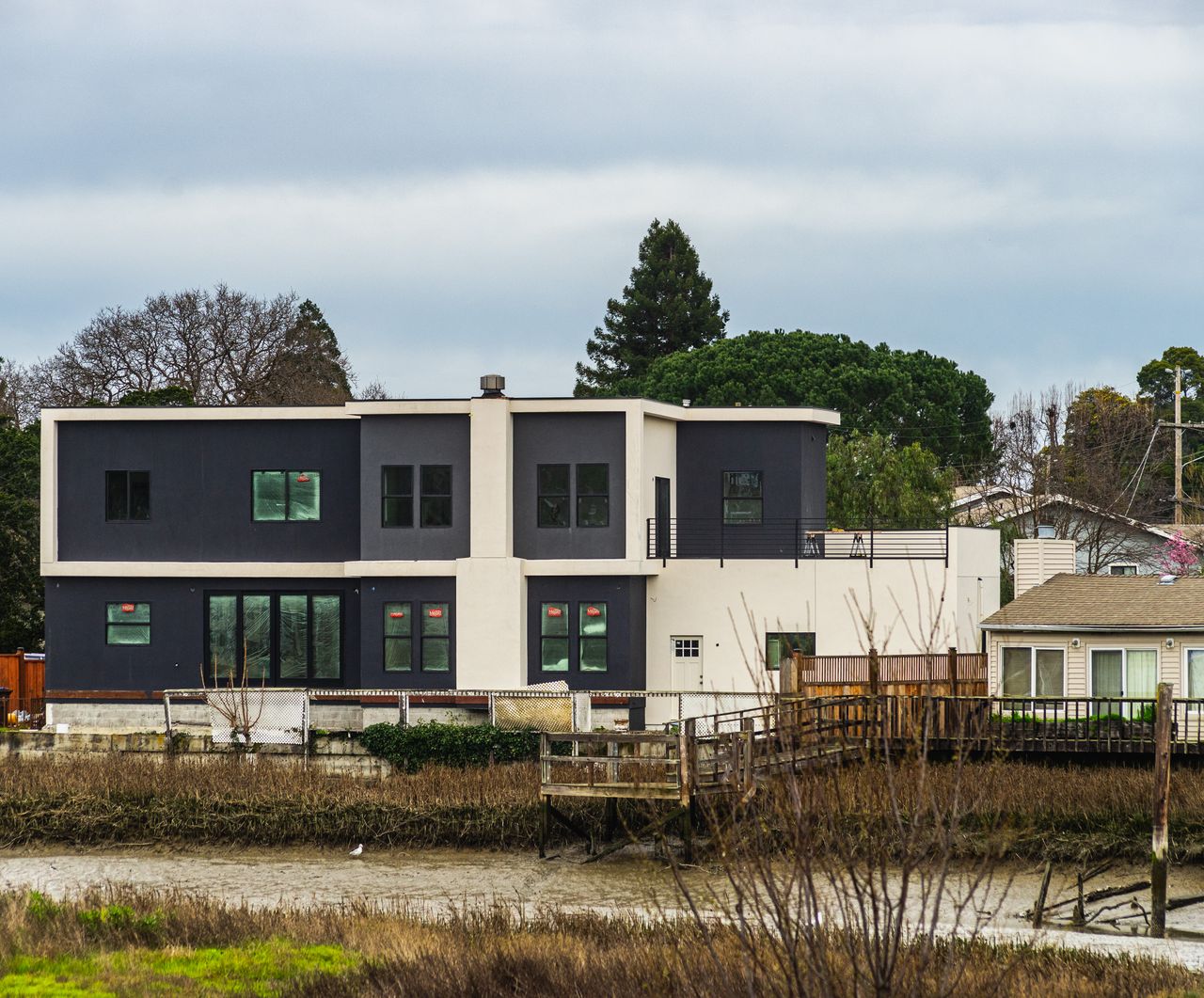 Contemporary two-story house near river with fresh architecture.